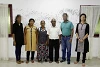 Pastor Raja mit Gemeindemitgliedern, Mitarbeiter der Evangelischen Allianz und die CSI-Projektleiterin vor verschmierter Wand (csi)