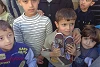 Flüchtlingskinder bekommen Schuhe (csi)