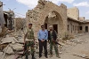 Der Bürgermeister von Sadat mit zwei Sicherheitsleuten vor einer zerstörten Kirche in der Stadt Karyatain (csi)
