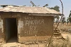 Dieses Haus wurde bei einem Angriff der Fulani-Miliz im Januar 2022 niedergebrannt. Sein Besitzer kehrte zurück, um eine Nachricht an die Wand zu schreiben. csi